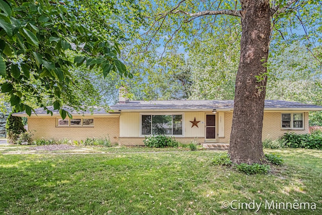 3343 Gateshead St NE, Rockford, MI 49341 - view of front of home with brick siding, a front yard, and a chimney