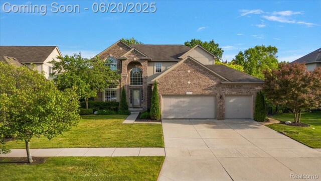 18852 Newbridge Dr, Macomb, MI 48044 - traditional home with a garage, a front yard, concrete driveway, and brick siding