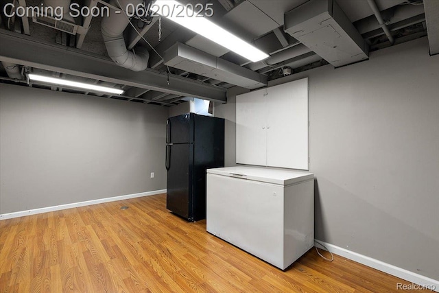 18852 Newbridge Dr, Macomb, MI 48044 - finished basement featuring fridge, freestanding refrigerator, and light wood-style floors
