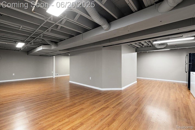18852 Newbridge Dr, Macomb, MI 48044 - finished basement featuring wood finished floors and freestanding refrigerator