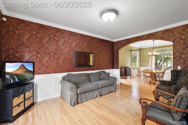 18852 Newbridge Dr, Macomb, MI 48044 - living room with a chandelier, wallpapered walls, arched walkways, a wainscoted wall, and wood finished floors