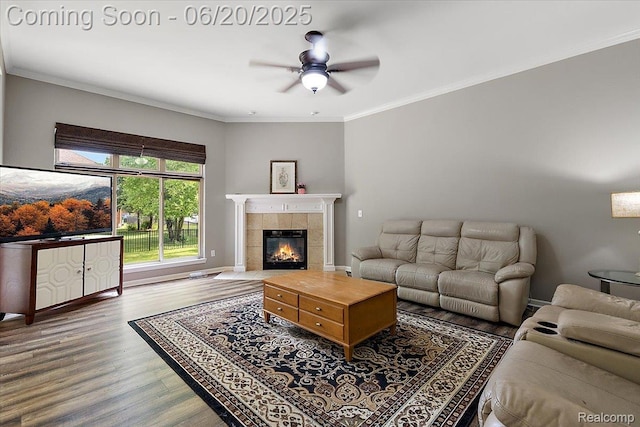 18852 Newbridge Dr, Macomb, MI 48044 - living room featuring wood finished floors, ceiling fan, a tiled fireplace, and crown molding