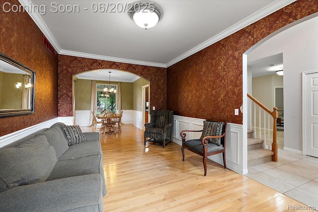 18852 Newbridge Dr, Macomb, MI 48044 - living area featuring arched walkways, a chandelier, wood finished floors, ornamental molding, and stairway