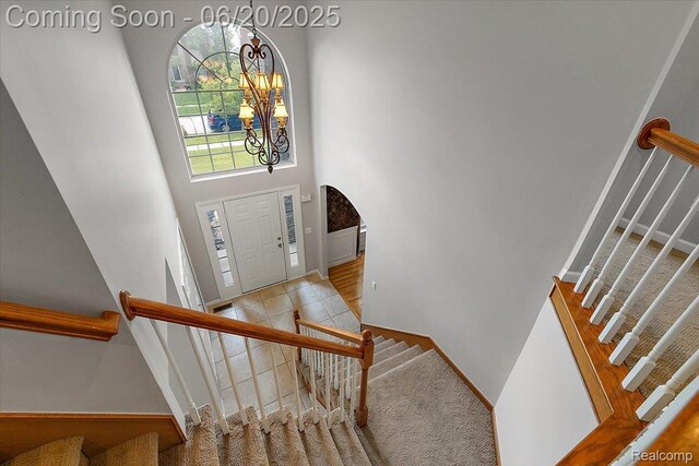 18852 Newbridge Dr, Macomb, MI 48044 - foyer entrance featuring stairway, a high ceiling, and a chandelier
