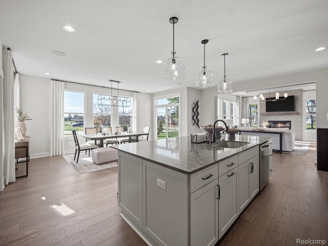 24654 Floret, Macomb, MI 48042 - kitchen featuring recessed lighting, a kitchen island with sink, stone counters, open floor plan, and hardwood / wood-style floors
