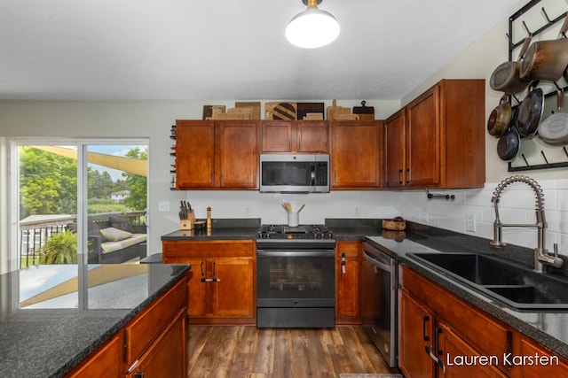 14734 Crescent Meadows Dr, Cedar Springs, MI 49319 - kitchen with stainless steel appliances, dark wood finished floors, decorative backsplash, and dark stone countertops