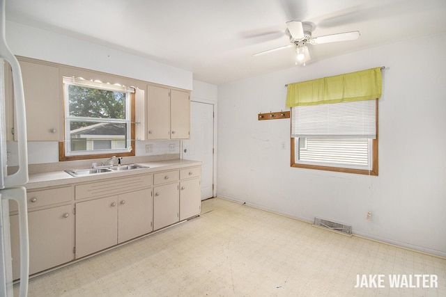 1428 Matilda St NE, Grand Rapids, MI 49503 - kitchen with light floors, light countertops, freestanding refrigerator, a ceiling fan, and cream cabinetry