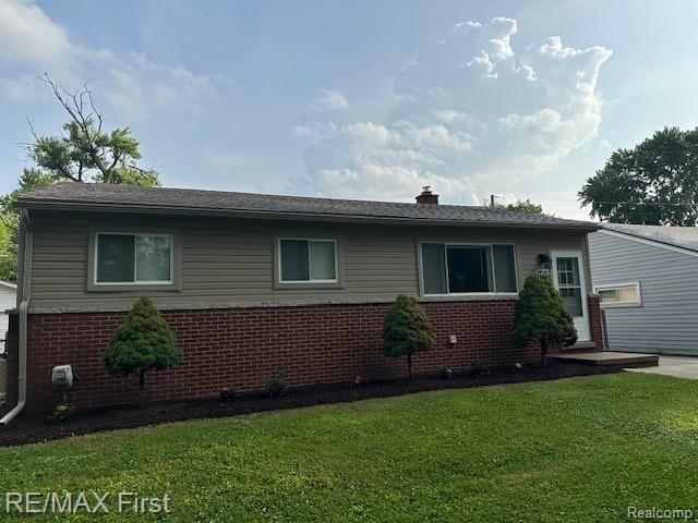 34940 John St, Wayne, MI 48184 - view of home's exterior with brick siding, a yard, and a chimney