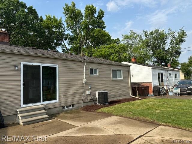 34940 John St, Wayne, MI 48184 - rear view of house featuring a patio, a lawn, and entry steps