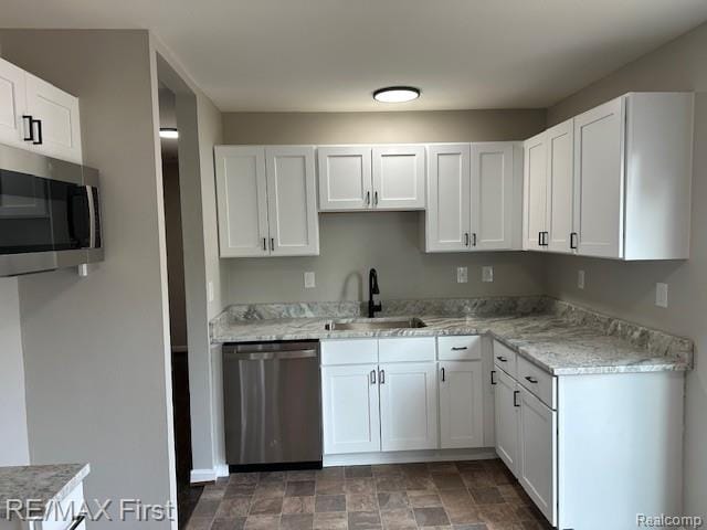 34940 John St, Wayne, MI 48184 - kitchen featuring appliances with stainless steel finishes, white cabinets, stone finish floors, and light stone countertops