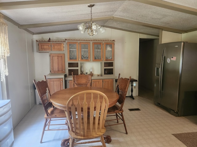 1593 W Centerline Rd, Baldwin, MI 49304 - dining area with lofted ceiling, a chandelier, and light floors