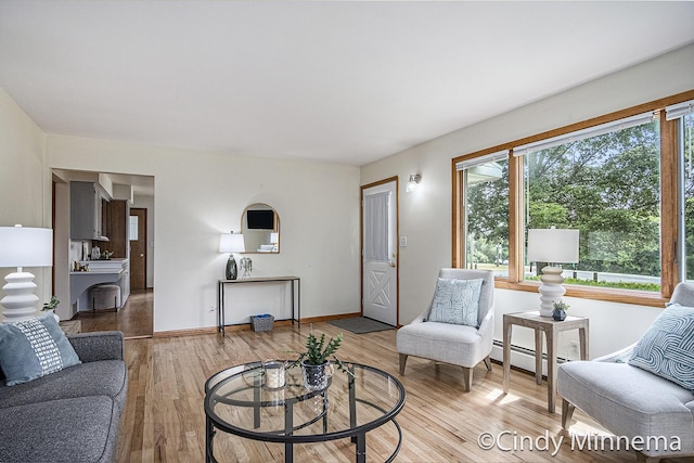 7080 Pine Island Dr NE, Comstock Park, MI 49321 - living area with a baseboard heating unit and light wood-type flooring