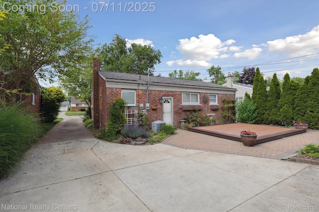 32203 Anita Dr, Westland, MI 48185 - view of front of property with a chimney, a deck, brick siding, and a patio area