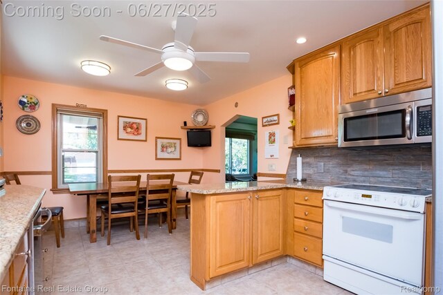 21626 Oconnor St, Saint Clair Shores, MI 48080 - kitchen featuring stainless steel microwave, white electric range oven, a peninsula, and healthy amount of natural light