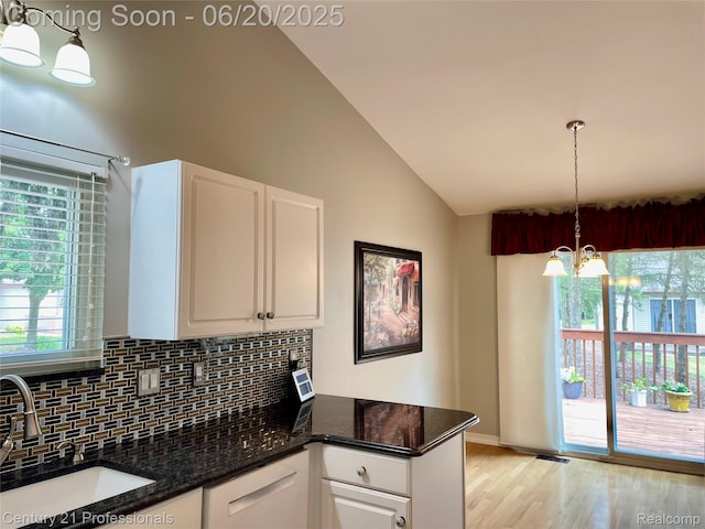 6850 Deerhurst Dr, Westland, MI 48185 - kitchen featuring tasteful backsplash, white cabinetry, a chandelier, a peninsula, and dark stone counters