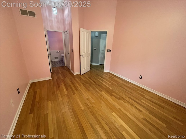 6850 Deerhurst Dr, Westland, MI 48185 - unfurnished bedroom with wood finished floors, a high ceiling, and connected bathroom