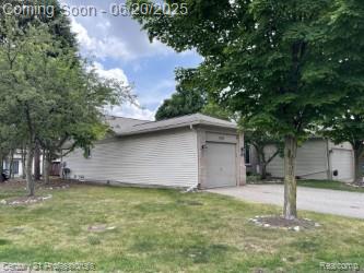 6850 Deerhurst Dr, Westland, MI 48185 - view of side of property with an attached garage, a yard, and driveway