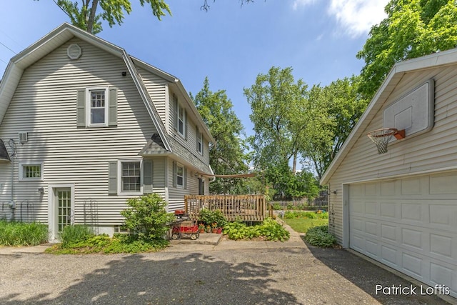 140 Lakeside Dr NE, Grand Rapids, MI 49503 - view of home's exterior with a gambrel roof, a garage, and a deck