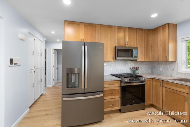 10829 26th Ave NW, Grand Rapids, MI 49534 - kitchen with appliances with stainless steel finishes, backsplash, light wood finished floors, and recessed lighting