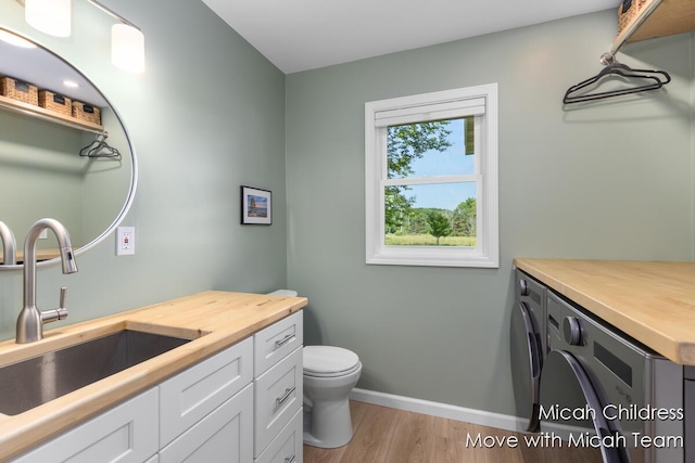 10829 26th Ave NW, Grand Rapids, MI 49534 - bathroom with washer and dryer, vanity, and wood finished floors