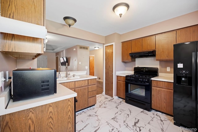 29680 Olympia Ct, Farmington Hills, MI 48336 - kitchen with black appliances, under cabinet range hood, light countertops, light marble finish flooring, and brown cabinetry
