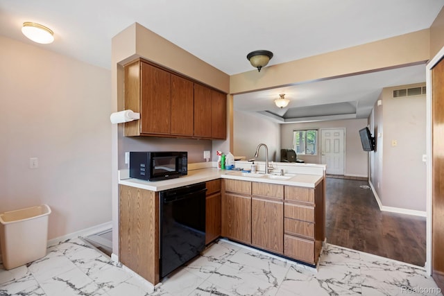 29680 Olympia Ct, Farmington Hills, MI 48336 - kitchen featuring black appliances, a peninsula, light countertops, brown cabinets, and light marble finish flooring