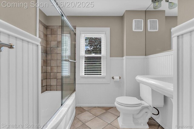 1717 Penistone St, Lake Orion, MI 48009 - bathroom with combined bath / shower with glass door, tile patterned floors, and a wainscoted wall