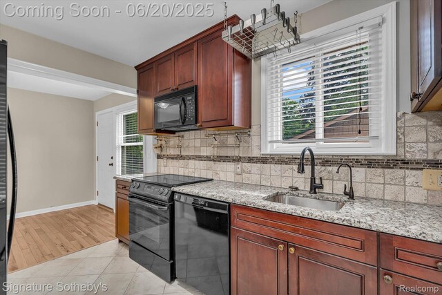 1717 Penistone St, Lake Orion, MI 48009 - kitchen with black appliances, decorative backsplash, light stone countertops, and plenty of natural light