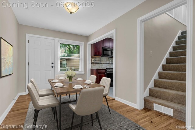 1717 Penistone St, Lake Orion, MI 48009 - dining space featuring light wood finished floors and stairway