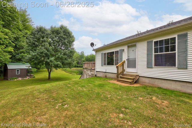 6275 Caine Rd, Vassar, MI 48768 - view of grassy yard featuring entry steps and a storage shed