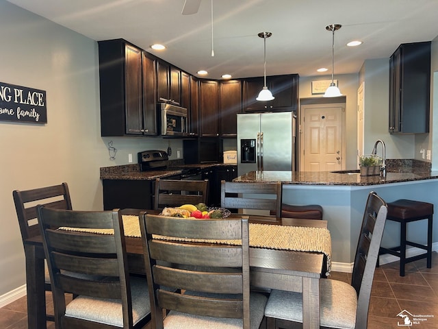 2118 Fountain Cir, Lambertville, MI 48144 - kitchen featuring stainless steel appliances, dark stone counters, a peninsula, dark brown cabinets, and dark tile patterned flooring