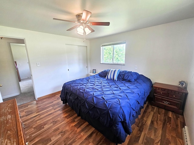 5365 Flushing Rd, Flushing, MI 48433 - bedroom featuring wood finished floors, a closet, a baseboard heating unit, and a ceiling fan