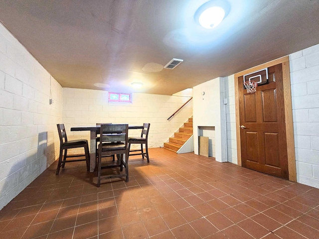5365 Flushing Rd, Flushing, MI 48433 - dining space featuring stairs, concrete block wall, and dark tile patterned flooring