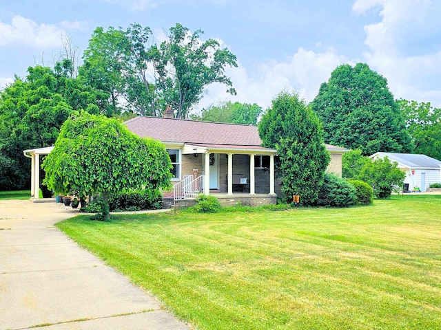 5365 Flushing Rd, Flushing, MI 48433 - view of front of home featuring a porch, a front lawn, driveway, a chimney, and brick siding