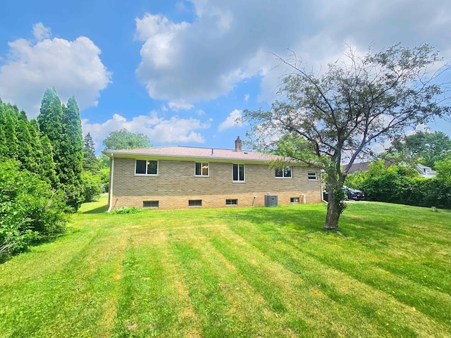 5365 Flushing Rd, Flushing, MI 48433 - rear view of house featuring a lawn and brick siding