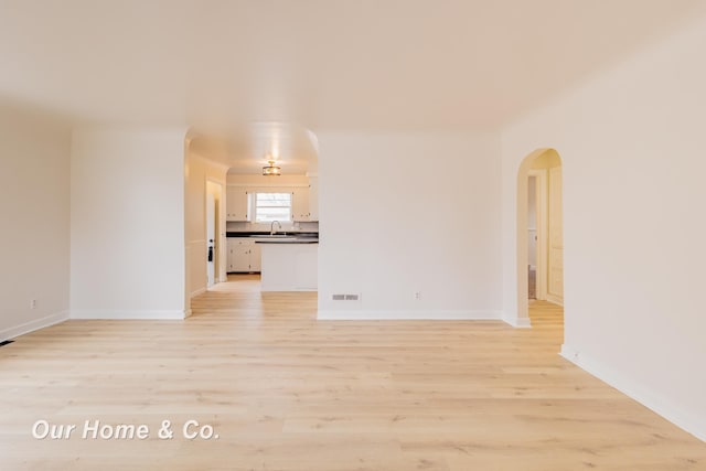 1716 Sycamore St, Saginaw, MI 48602 - unfurnished room featuring arched walkways and light wood-style flooring