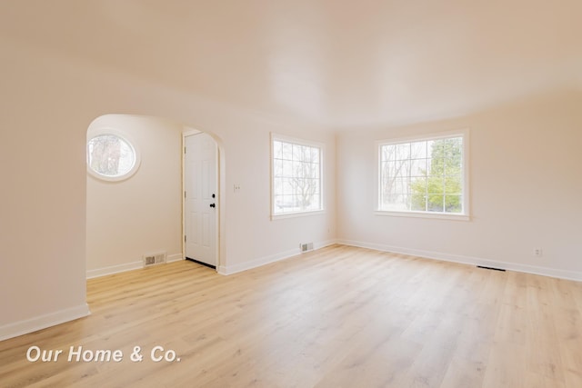 1716 Sycamore St, Saginaw, MI 48602 - empty room with arched walkways and light wood finished floors