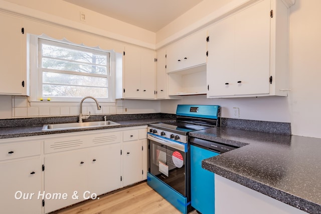 1716 Sycamore St, Saginaw, MI 48602 - kitchen with electric range, dark countertops, white cabinetry, and light wood-style floors