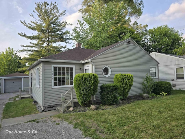 1716 Sycamore St, Saginaw, MI 48602 - view of property exterior with a chimney, a yard, an outdoor structure, driveway, and a detached garage