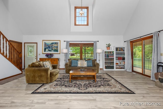 8651 22 Mile Rd NE, Sand Lake, MI 49343 - living room featuring high vaulted ceiling, healthy amount of natural light, wood finished floors, and stairway