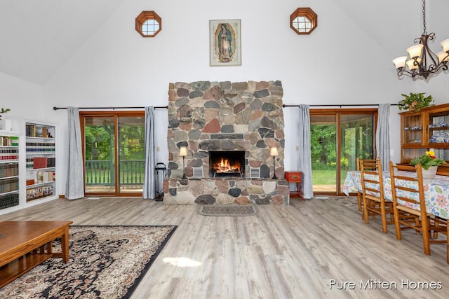 8651 22 Mile Rd NE, Sand Lake, MI 49343 - living area featuring high vaulted ceiling, a chandelier, a fireplace, wood finished floors, and plenty of natural light