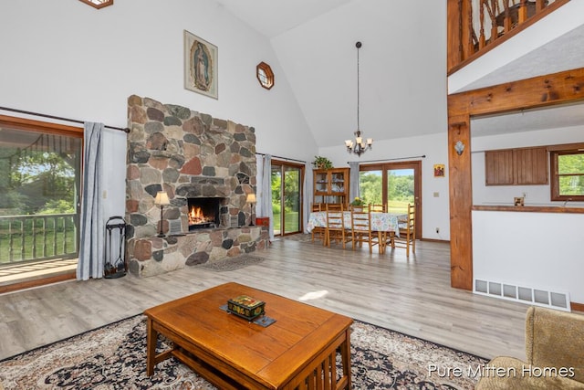 8651 22 Mile Rd NE, Sand Lake, MI 49343 - living room featuring high vaulted ceiling, wood finished floors, a chandelier, and a fireplace