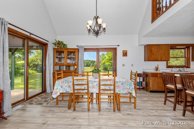 8651 22 Mile Rd NE, Sand Lake, MI 49343 - dining area with high vaulted ceiling, a chandelier, and light wood-style floors