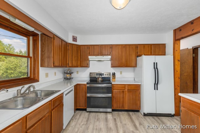 8651 22 Mile Rd NE, Sand Lake, MI 49343 - kitchen with freestanding refrigerator, range with two ovens, under cabinet range hood, dishwashing machine, and light countertops