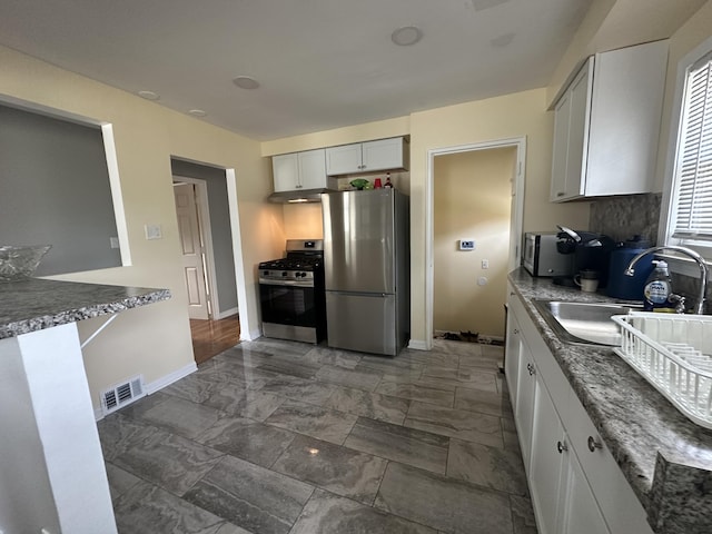29635 Julius Blvd, Westland, MI 48186 - kitchen featuring stainless steel appliances, dark marble finish floors, under cabinet range hood, and tasteful backsplash