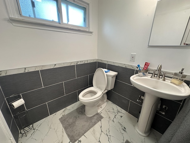 29635 Julius Blvd, Westland, MI 48186 - half bathroom with tile walls, marble look tiles, and a wainscoted wall