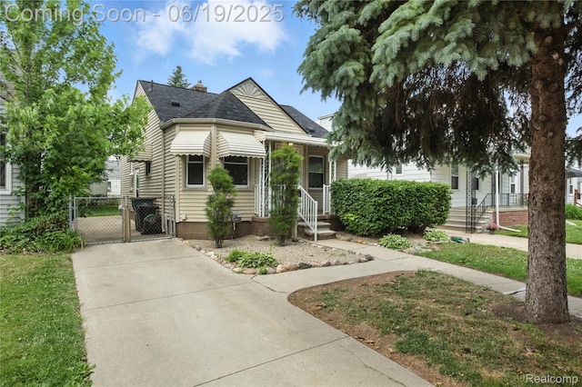 507 Spencer St, Ferndale, MI 48220 - view of front of home with a gate, concrete driveway, and a chimney