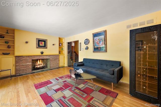 7189 Lindenmere Dr, Bloomfield Hills, MI 48301 - living area with a fireplace, built in features, wood finished floors, and stairway