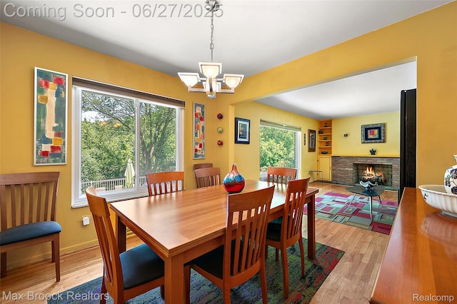 7189 Lindenmere Dr, Bloomfield Hills, MI 48301 - dining area with light wood-style floors, a chandelier, and a fireplace