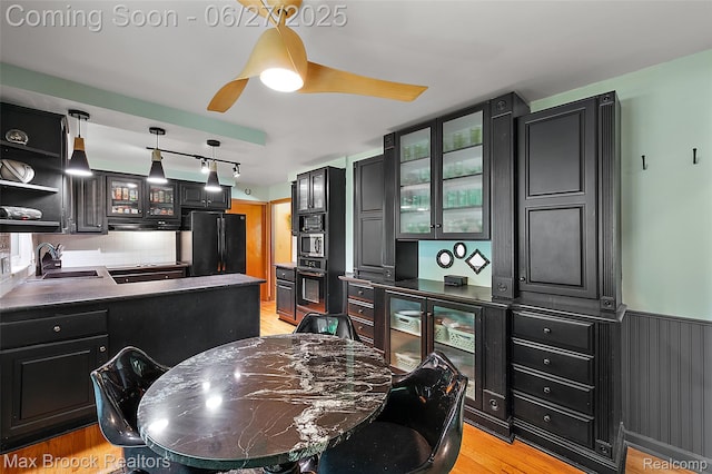 7189 Lindenmere Dr, Bloomfield Hills, MI 48301 - kitchen featuring black appliances, glass insert cabinets, light wood-type flooring, dark countertops, and dark cabinetry